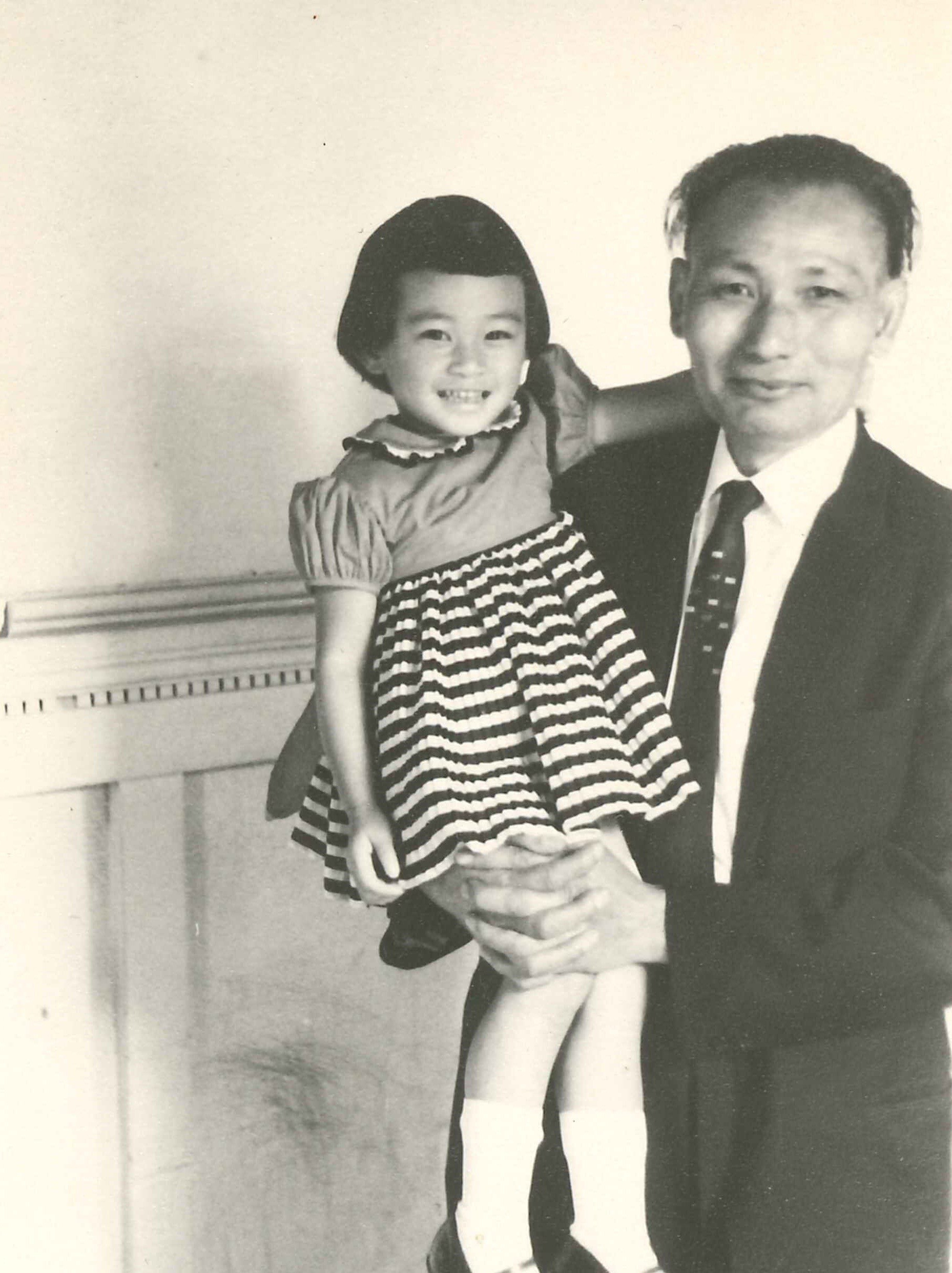 Dad and Lily pose in front of her pencil wall art
