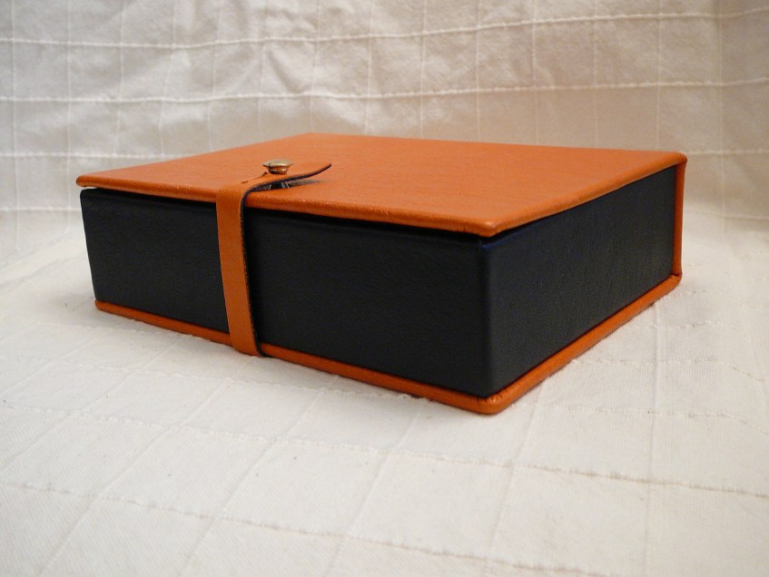 Jewellery case. Leather and fabric with strap and knob closure.