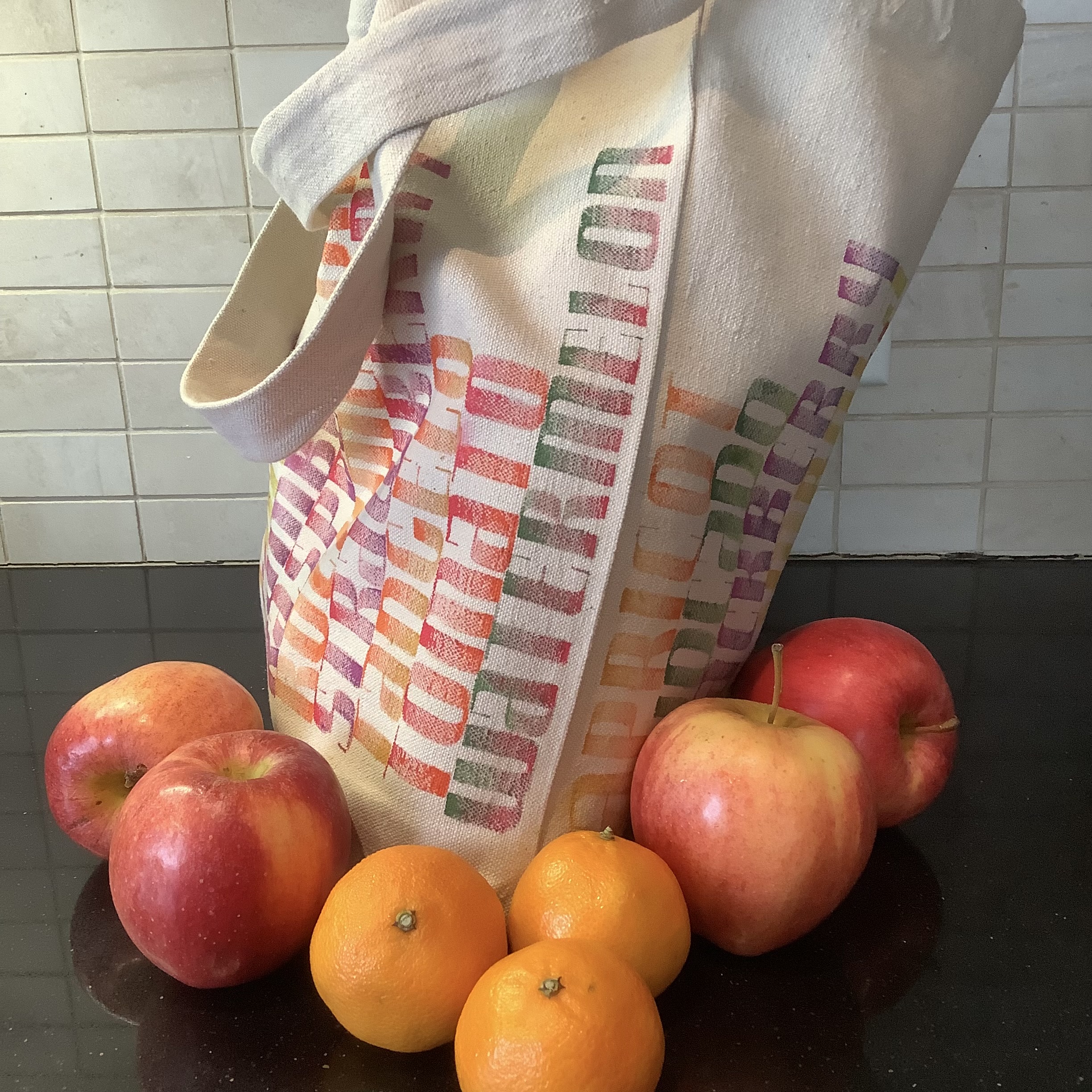 Side view of tote bag lettered with names of fruit